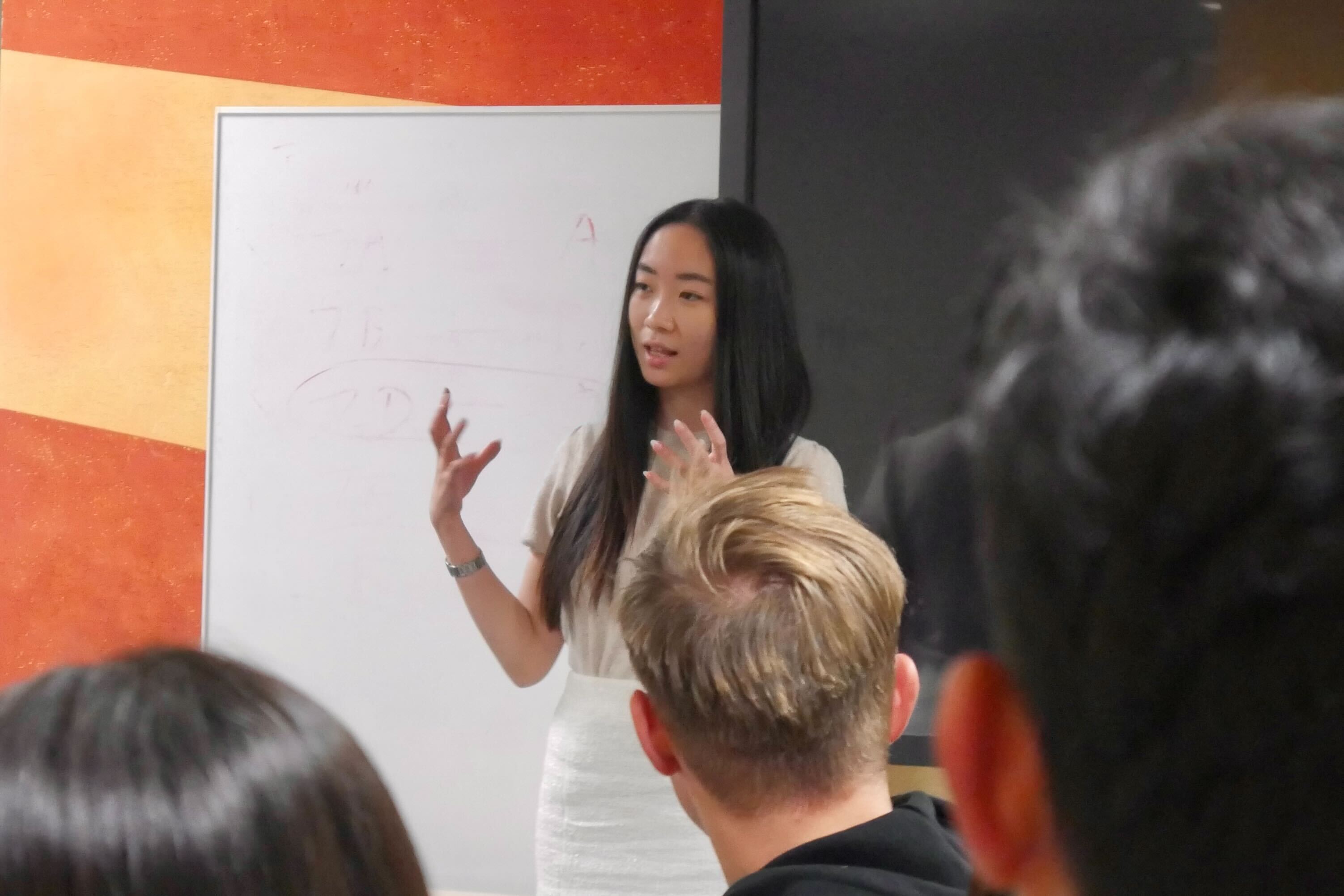 A B2 student presenting analysis at the whiteboard