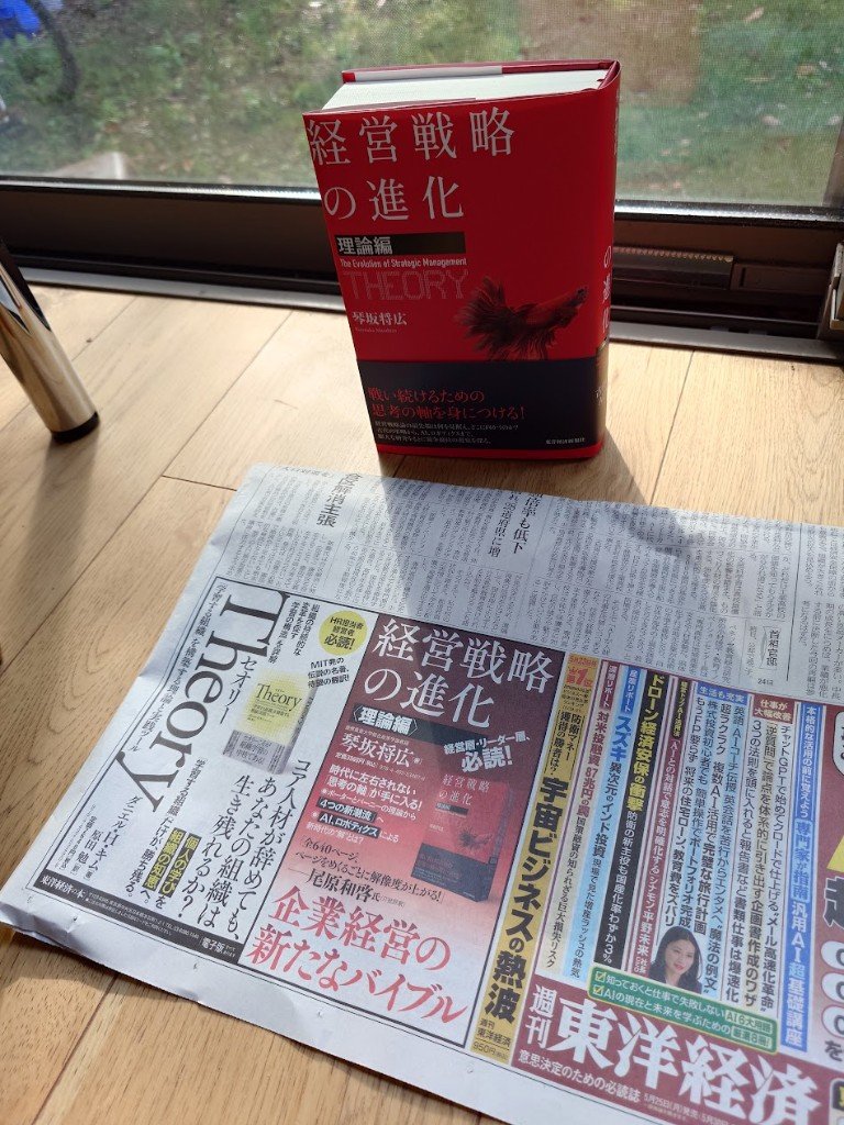 『経営戦略の進化〈理論編〉』の書籍と、2026年5月25日付『日本経済新聞』朝刊2面に掲載されたカラー広告