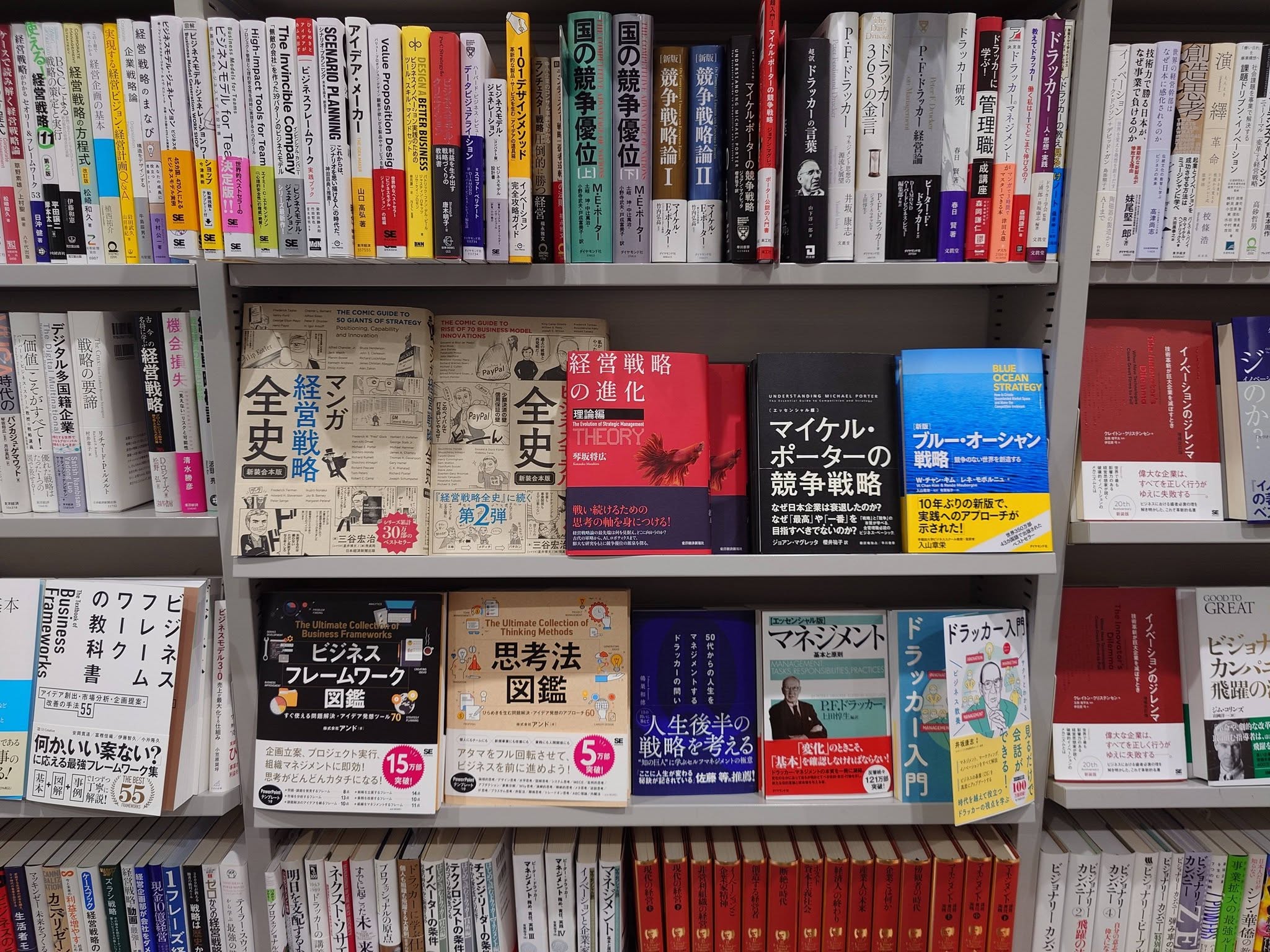 丸善・丸の内本店の棚に、表紙が見える面陳列で並ぶ『経営戦略の進化〈理論編〉』。マイケル・ポーター『競争戦略』やW・チャン・キム/レネ・モボルニュ『ブルー・オーシャン戦略』などの戦略書とともに置かれている。