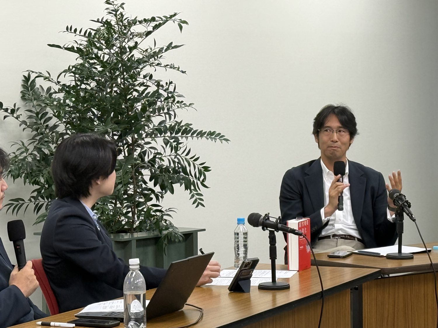 特別対談で語り合う琴坂将広（右）と株式会社PoliPoli 代表取締役CEO 伊藤和真氏（左）。テーブルには琴坂の新刊『経営戦略の進化〈理論編〉』。